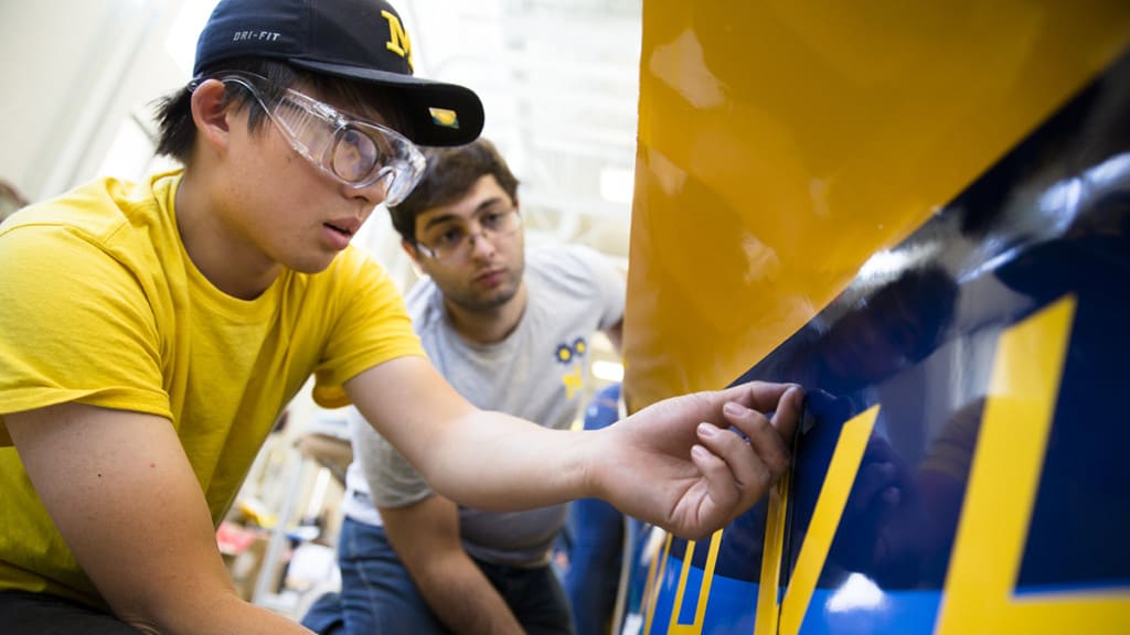 student on University of Michigan Solar Car Team's checking the fit of fairings