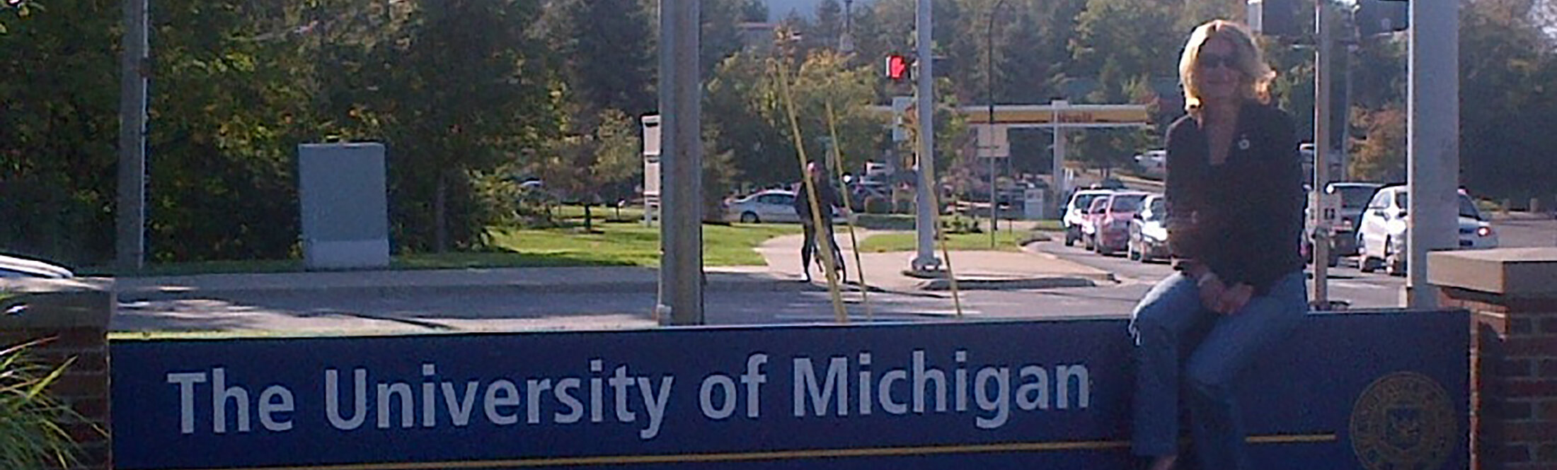 trudy kortes sitting on U-M North Campus Sign